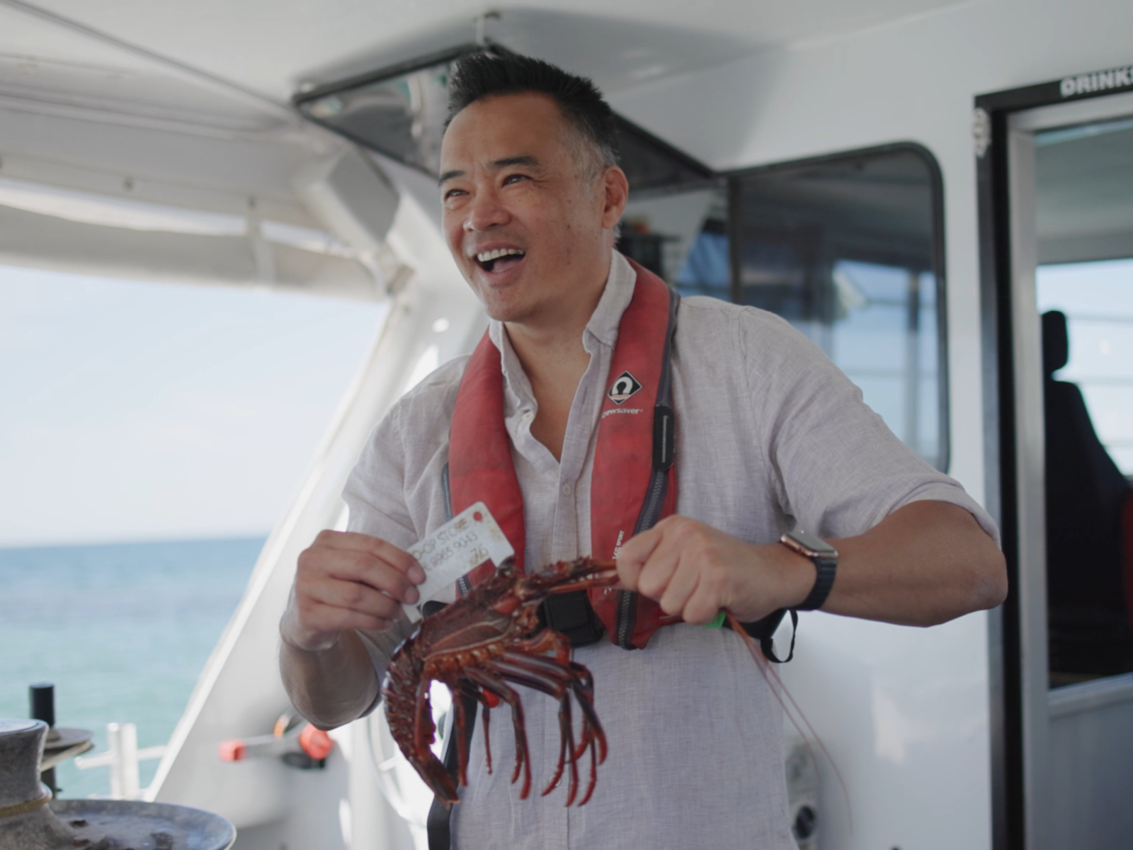 Image of a guest getting involved by sizing a lobster on a Geraldton Lobster Pot Pull Tour